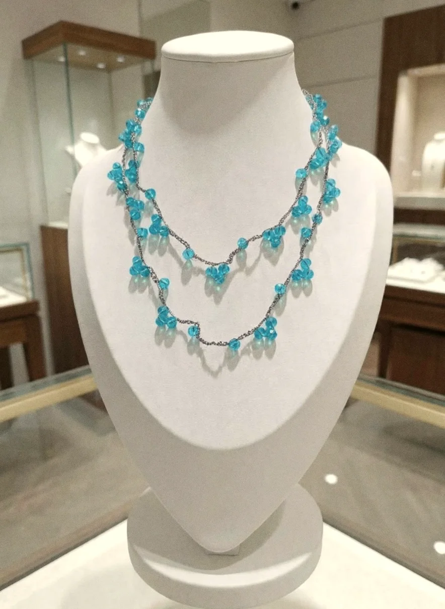 Collana Stromboli turchese a due giri con grappoli di cristalli su filo argentato, su un busto bianco