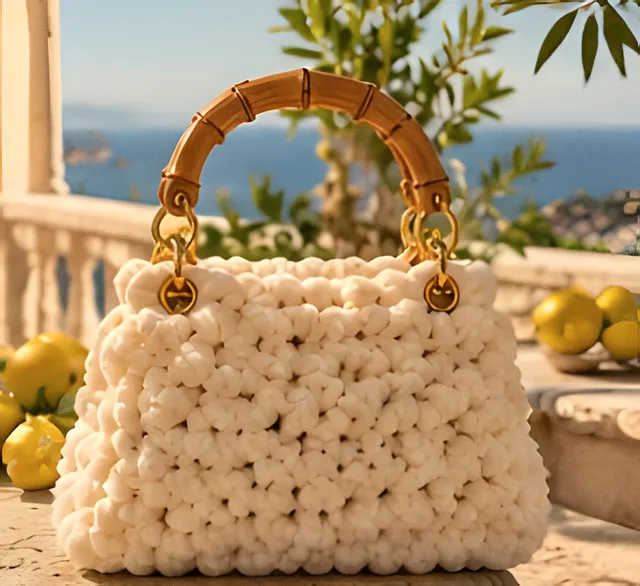 Borsa Lipari avorio con manico in bambù su una balaustra, limoni e mare sullo sfondo