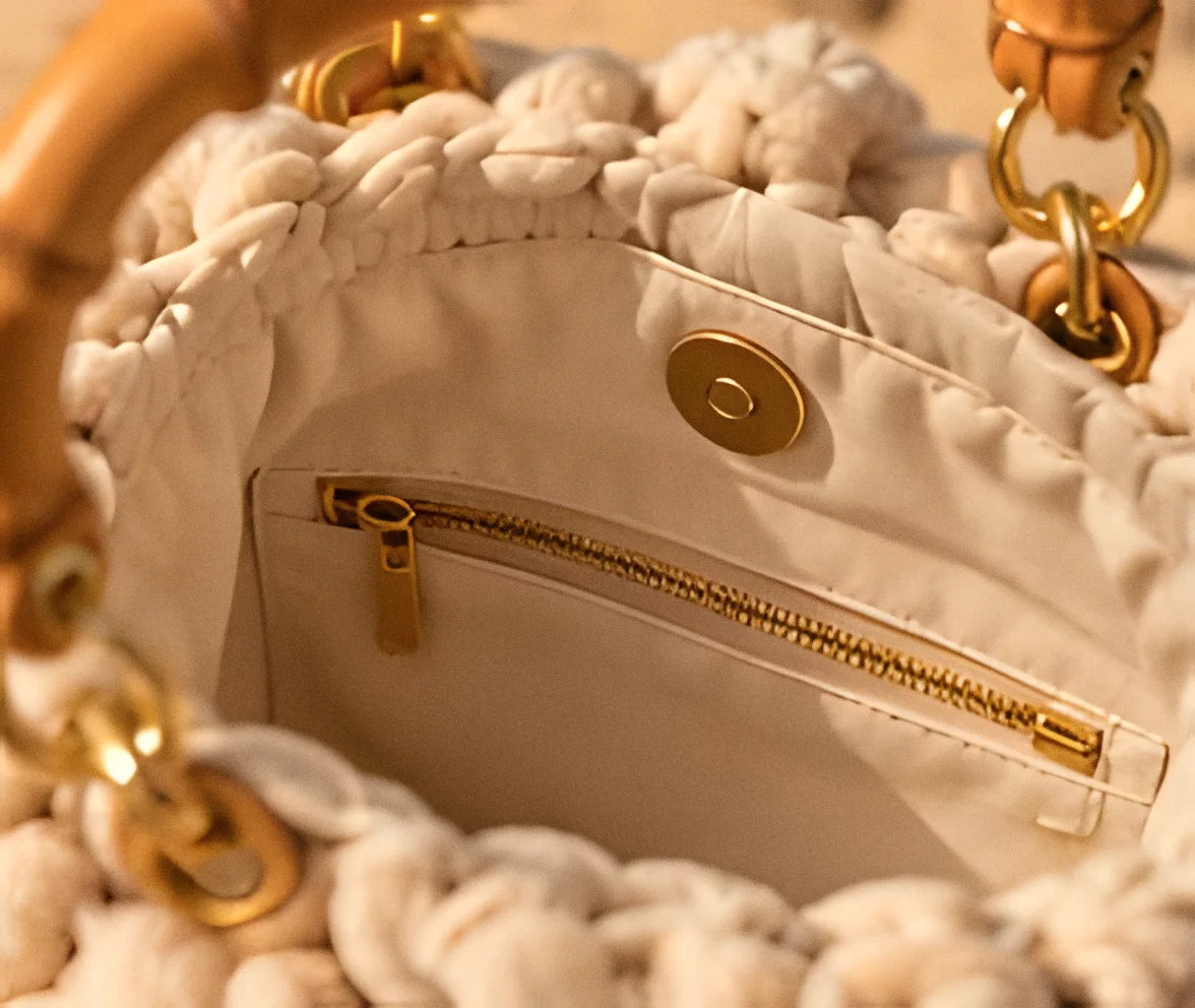 Interno della borsa: fodera avorio, tasca con zip dorata e bottone magnetico