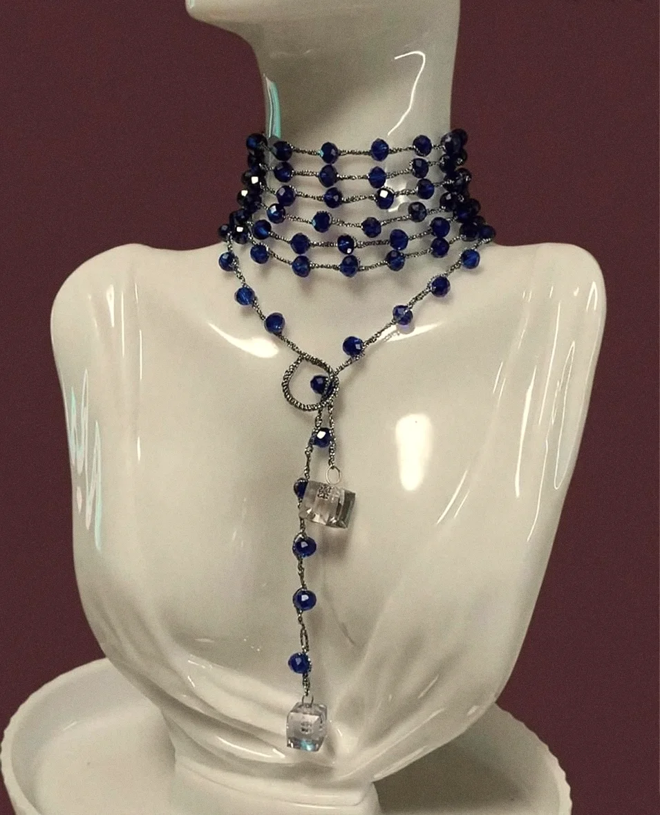 Collana Stromboli blu notte avvolta a più giri come girocollo, con il nodo e i cubi di cristallo