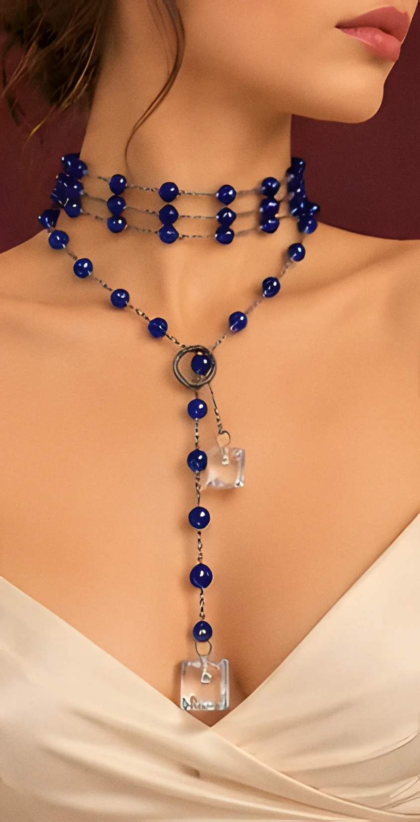 Collana Stromboli blu notte indossata su un abito avorio, girocollo e pendente lungo