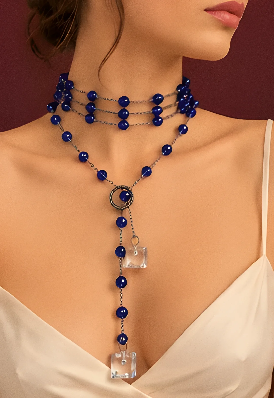 Collana Stromboli blu notte indossata con un abito avorio a spalline sottili
