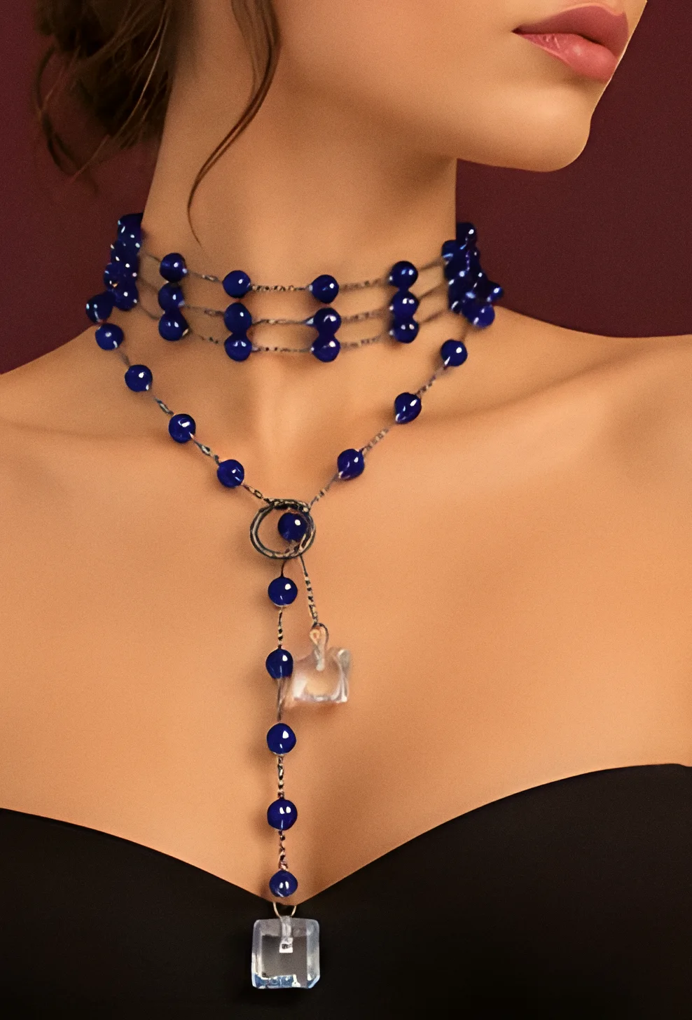 Collana Stromboli blu notte indossata come girocollo a più fili, con il pendente e il cubo di cristallo sul décolleté