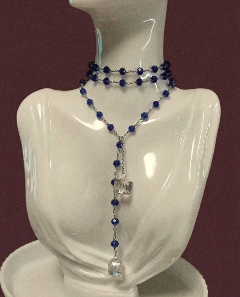 Collana Stromboli blu notte portata a doppio giro con le estremità a cascata, su un busto bianco