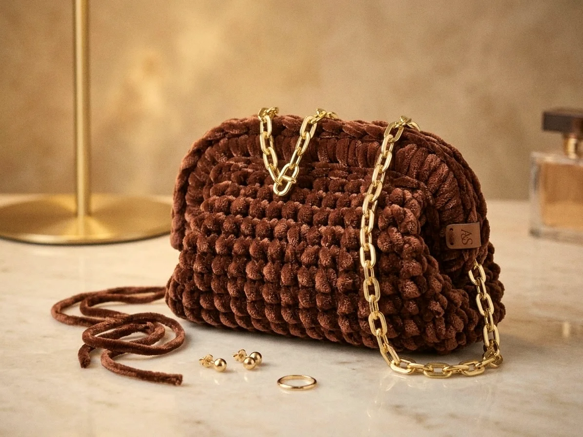 Borsa Taormina in velluto cioccolato con catena dorata su marmo chiaro