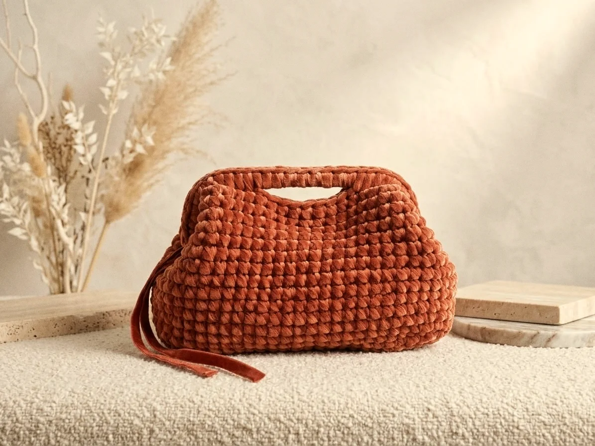 Pochette Tindari in velluto terracotta su un tessuto bouclé, con rami secchi e pampas