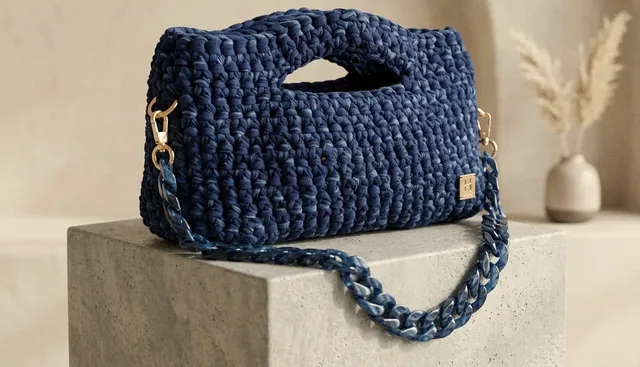 Bauletto Ustica blu mare con catena in resina abbinata, su un blocco di pietra