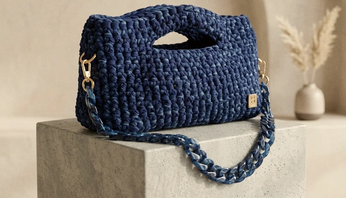 Bauletto Ustica blu mare con catena in resina abbinata, su un blocco di pietra